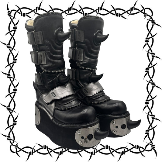 Black leather boots with metal accents on a white background with barbed wire border