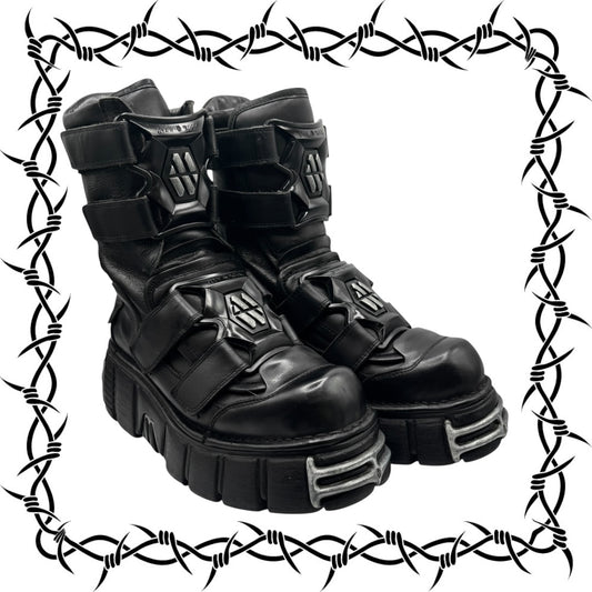 Black high-top boots with metallic accents on a barbed wire border