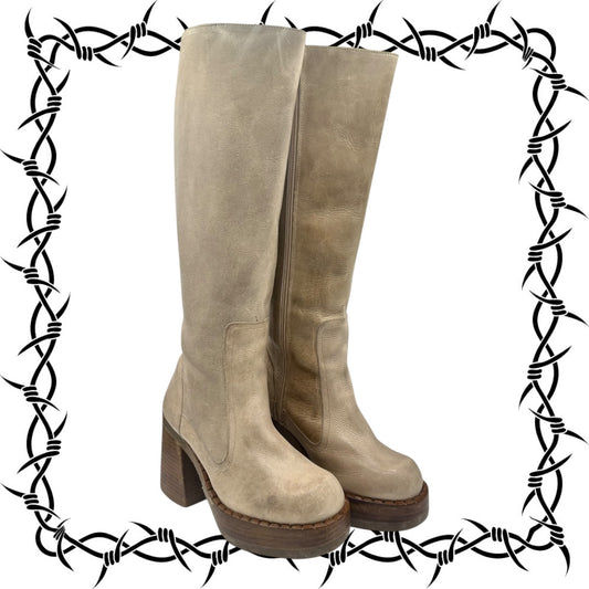 Pair of Destroy beige knee-high boots with a barbed wire border on a white background