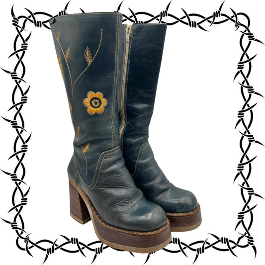 Pair of blue leather boots with floral embroidery on a white background